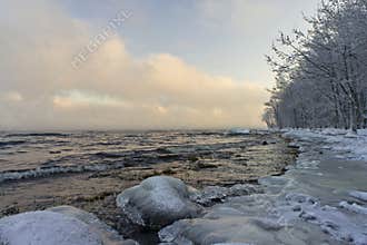Winter fog over Ladoga Lake and icy coastline