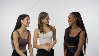 Portrait of young multiethnic models on white studio background close up. Group of three appealing multiracial girls