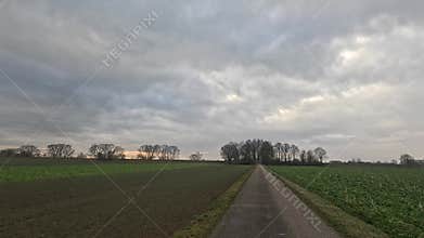 Car ride to the horizon between fields and meadows and clouds