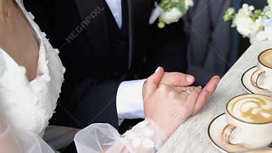Young married couple holding hands in cafe