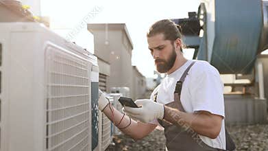 Man builder applying measuring device to conditioner outdoor