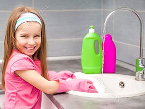 Little girl washing the dishes