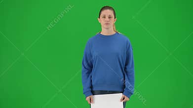 A young woman activist walks onto the green screen and holds a poster that says Let&#x27;s build a better world together