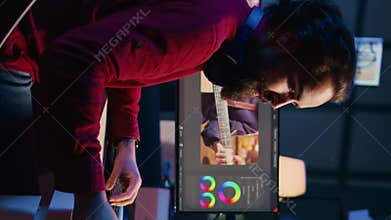 Vertical video Videographer adjusting clips while enjoying cup of coffee in office
