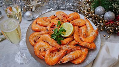 Cooked shrimps on a plate rotating, Christmas New Year decoration, pour champagne into a glass. Close up