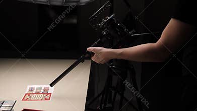 The videographer's hand adjusts the macro lens