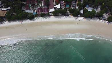 erial view of ocean waves crashing on a white beach
