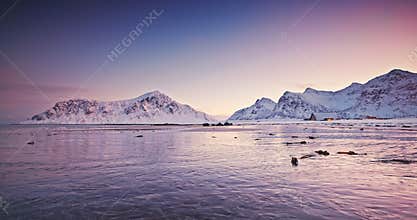 Scenery sunset winter landscape of frozen rocky ocean coastline Lofoten islands, Norway