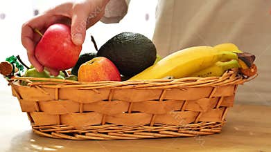 Fruit basket on a wooden table.avocados, bananas, apples and pears in a basket. fresh fruits and vegetables