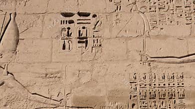 Ancient Egyptian hieroglyphs and bas-reliefs close-up in Temple of Medinet Habu. Egypt, Luxor. The Mortuary Temple of