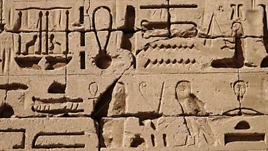Ancient Egyptian hieroglyphs and bas-reliefs close-up in Temple of Medinet Habu. Egypt, Luxor. The Mortuary Temple of