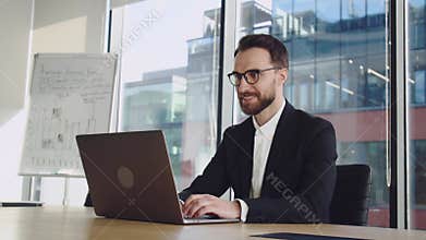 Happy businessman trader working looking at laptop computer screen thinking analyzing online trading market finance