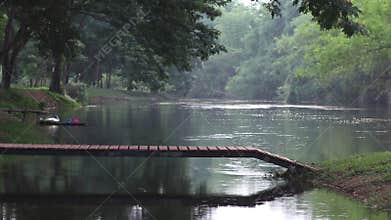 Wooden bridge with green trees and river in background