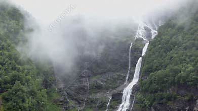 Brook and river with waterfall on rocky mountain