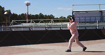 A young woman does lunges for the muscles of her legs and buttocks.
