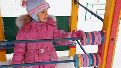 little girl playing with abacus in winter city