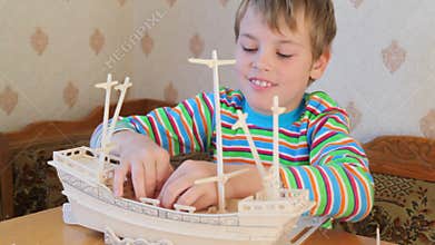 smiling happy boy constructing toy model of