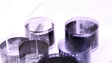 rolls of black and white negative film revolve on