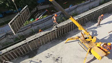 Small crane lifts part of wall and carries it,