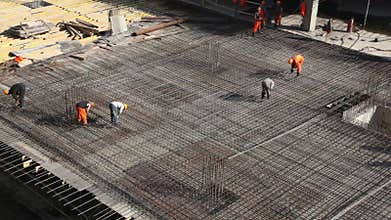 Several workers constructing metal frame on