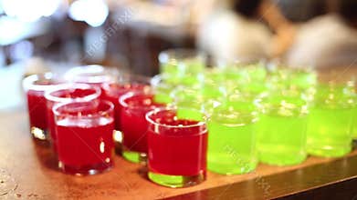 Barman hands put glasses with red and green