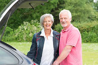 Senior couple with black car