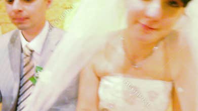 bridegroom and bride sits at wedding table, camera