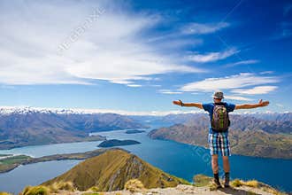 Hiker at the top of a rock with his hands raised