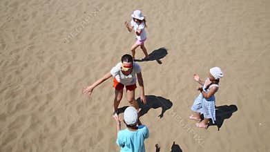 Mother with three children play blindman buff on