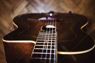 An acoustic gypsy jazz guitar on a stand in the room