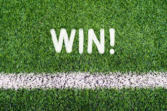 WIN hand writing text on soccer field grass
