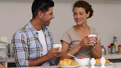 Happy couple chatting and having breakfast together