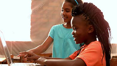 Little girls using laptop in classroom