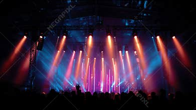Stage Lights Move in Sync With Music at a Lively Concert in an Outdoor Venue During the Evening