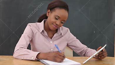 Video of a teacher smiling while using a tablet computer