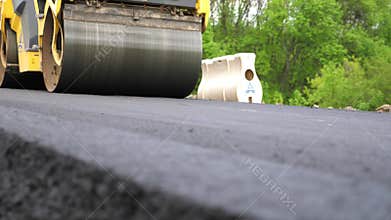 Compactor constructing highway. Steamroller slowly ride. Roadway repair by heavy machinery. Roller laying new asphalt layer