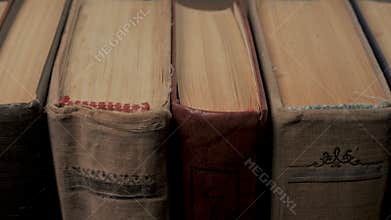 Vintage hardcover books spines aligned vertically with aged paper edges