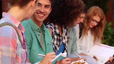 Students sitting in a row writing in notebooks