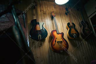 Old jazz guitars on the wall with paneling