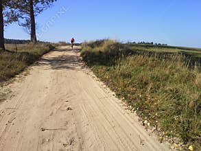 Distant MTB cyclist on dirt path