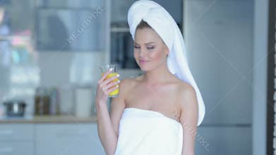 Woman in towel drinking juice