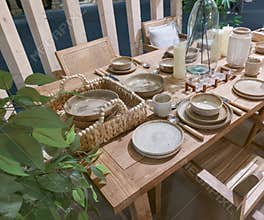 Dining setup with tableware and plants in a natural wood environment ready for a meal gathering