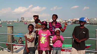 Afro-American family sings a song on the shore of the Gulf of Siam in Pattaya. Part 3