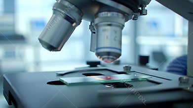 Modern Research Microscope Close Up with Glass Slide Containing Pink Specimen in Bright Lab Background Scientific Research Tool