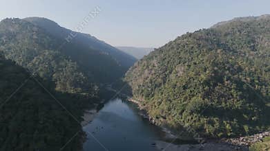 Majestic aerial view of the Umngot River flowing through a deep jungle gorge in Shnongpdeng, Meghalaya, India