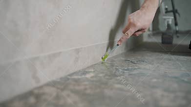 Worker applying grout to tile edges in home renovation project with precision tools for a seamless finish