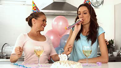 Woman blowing candle while celebrating her birthday with a friend