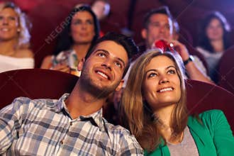 Happy couple watching movie in cinema