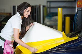 Car wrapper preparing foil to wrap a vehicle