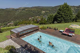 A family enjoys the pool on a bright summer day.